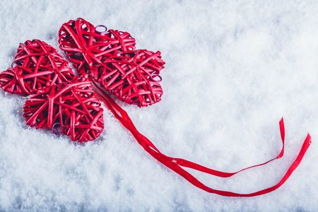 beautiful romantic vintage red hearts together in clover shape on a white snow background.の写真素材