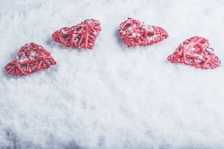 Four beautiful romantic vintage hearts on a white frosty snow winter background.の写真素材