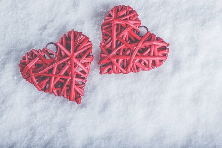 Two red hearts on a white snow winter background.の写真素材