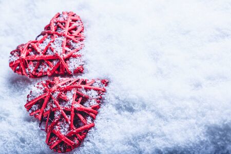 Two red hearts on a white snow winter background.の写真素材