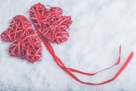 Four red hearts on a white snow winter background.の写真素材