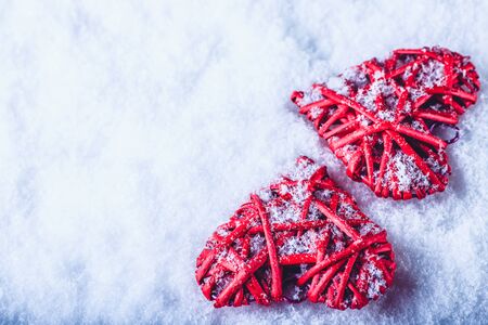 Two red hearts on a white snow winter background.の写真素材