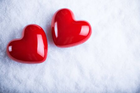 Two red hearts on a white snow winter background.の写真素材