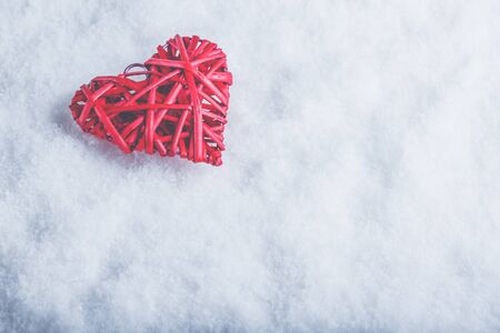 A red heart on a white snow winter background.の写真素材