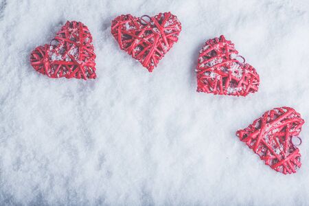 Four red hearts on a white snow winter background.の写真素材