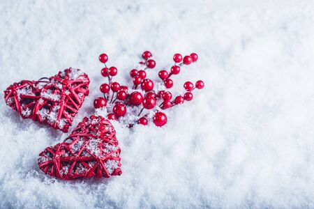 Two  hearts with mistletoe berries on a white snow winter background.の写真素材