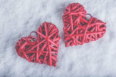 Two red hearts on a white snow winter background.の写真素材