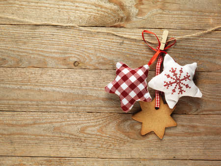 Gingerbread cookies and christmas decorations hanging over wooden background.の写真素材