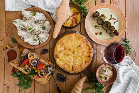 A lot of food on the wooden table. Georgian cuisine. Top view. Flat lay . Khinkali and Georgian dishesの写真素材