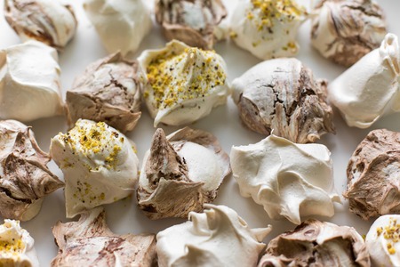 Closeup of mini meringues on white as food background. Top view. Different homemade meringues on a light backgroundの写真素材