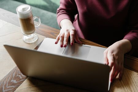 Female working on laptop in a cafe. woman using laptop in home. using laptop internet. hand using laptop in coffe shopの写真素材