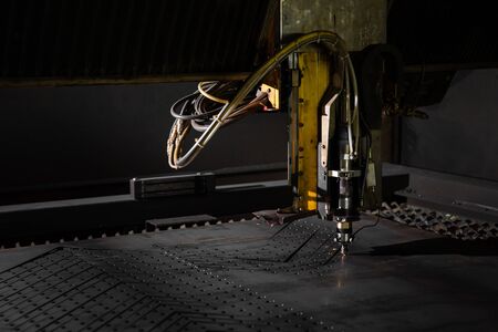 Laser machine, cuts metal, sparks. Industrial cnc plasma machine cutting of metal plateの写真素材