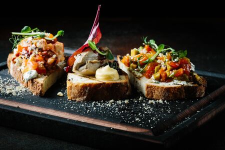 Delicious Italian bruschetta with tomato, meat pate, olives, cream cheese. Set of tasty appetizer sandwichesの写真素材