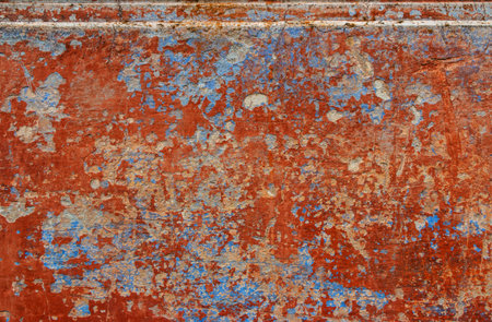 Grunge blue and red wall with peeling paint. Abstract background.
