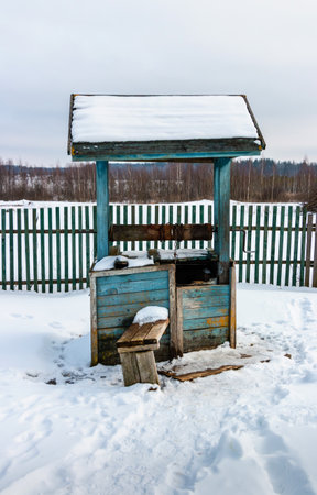 Old wooden well in the village in winter, Belarusの写真素材