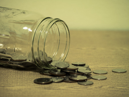 Money coins and jar on wood tableの写真素材