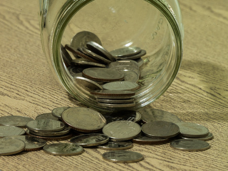Money coins in the jar on wood table