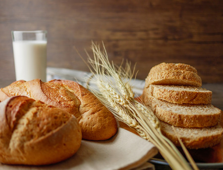 Various of breads on wooden table with milk and newspaper breakfast table with copy space ...