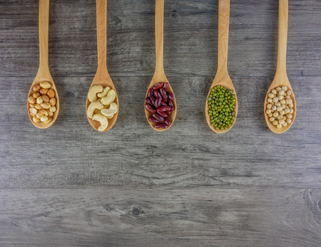 Flat lay variety of beans included cashews,green beans,red beans,peanut and soy beans   on wooden...