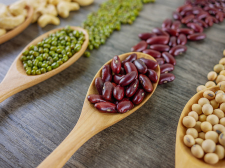 Variety of beans included cashews,green beans,red beans and soy beans  close up on wooden table ...
