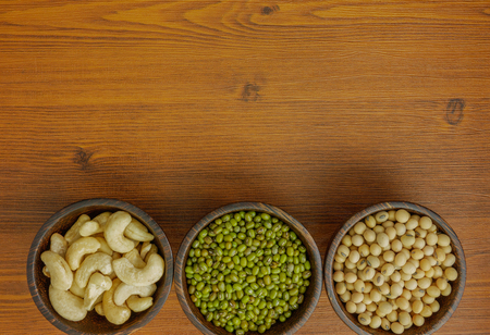 Flat lay,top view assorted beans included cashews green beans and soybeans on wooden table with copy spaceの写真素材