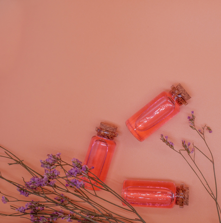 Flat lay essential oil and flowers on pink background with copy space beauty,spa,health conceptの写真素材