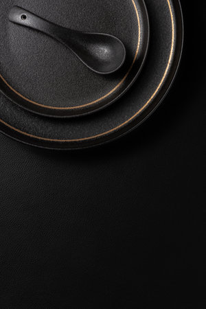 Frosted spoon on a ceramic dinner plate. The background is black leather. Luxurious, sumptuous fine...