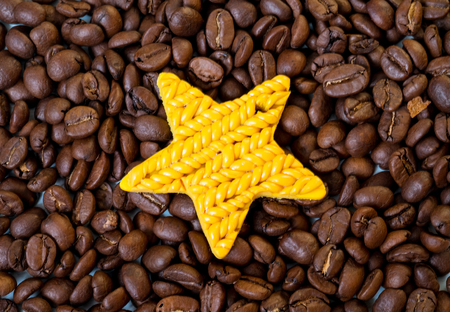 Yellow toy star and coffee beans - macro shotの写真素材
