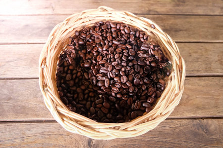 coffee beans in basket on wooden tableの写真素材