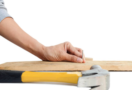 Carpenter is hum-mering a nail into a woodの写真素材