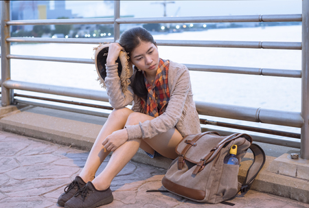 Asian female tourists backpack Asian female tourists are suffering from stress fatigue and unhappy During the trip On the roadside on holiday.の写真素材