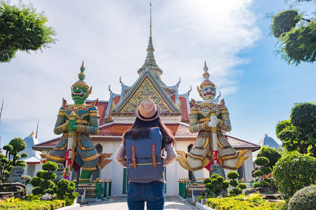 Asian woman tourists are visiting two giants during the relax holidays. at arun temple the landmark of Bangkok, Thailandの写真素材