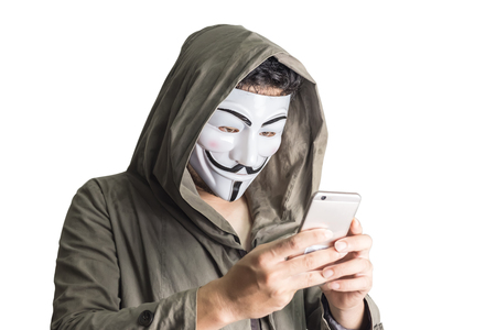 Bangkok, Thailand - May 6, 2018 : A hacker wears a mask wearing a robe. using smartphone theft and attacking data on cyberspace. Isolated on white backgroundのeditorial素材
