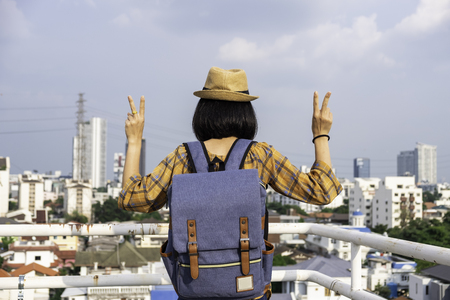 Asian girl tourists Traveling backpackers stand to admire the beauty of the building. and landscape of Bangkok, Thailand. during his vacation trip.