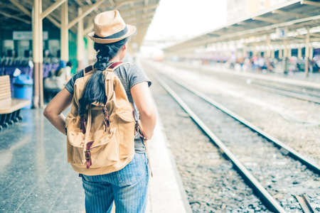 Asian woman tourist standing carrying a backpack. Wait for the train at Hua Lamphong Bangkok Thailand. During his travels in vacation.の写真素材