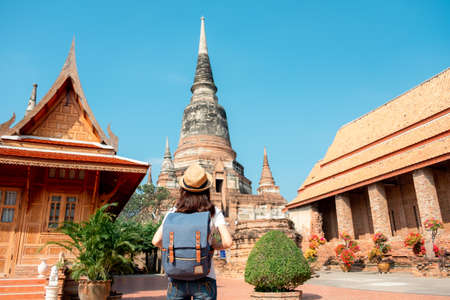 Asian woman tourists carrying a backpack and wearing a hat Visit Wat Yai Chaimongkol, the historical archaeological site of Phra Nakhon, Ayutthaya.の写真素材