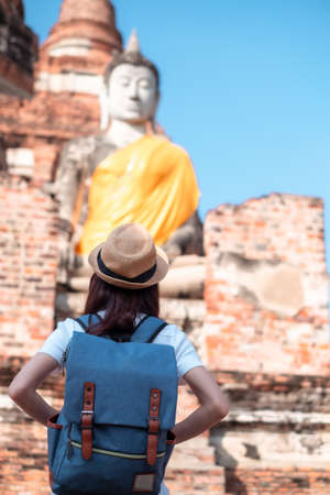 Asian woman tourists carrying a backpack and wearing a hat Visit Wat Yai Chaimongkol, the historical archaeological site of Phra Nakhon, Ayutthaya.の写真素材