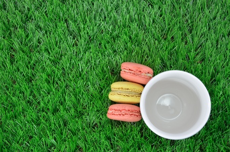 Macaroons close up with glass on grass background の写真素材