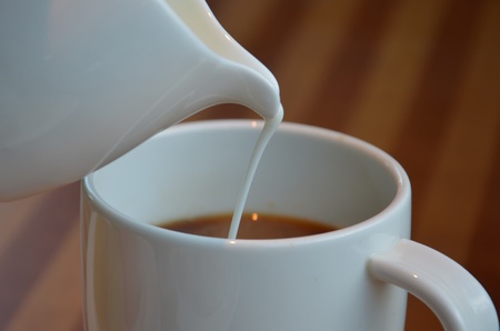 pouring into the white cup  Shot on light wood backgroundの写真素材