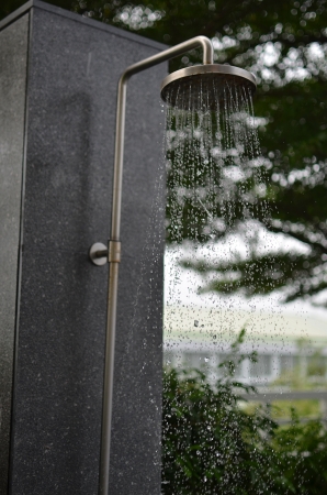 Water flowing in a old metal showerの写真素材
