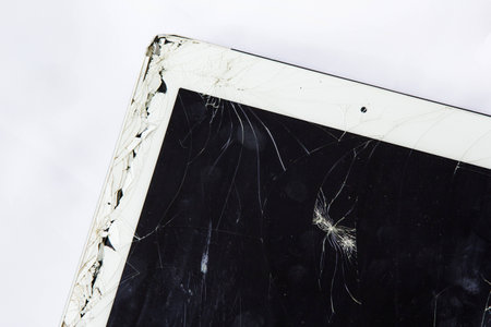 Tablet with broken glass screen on white background.