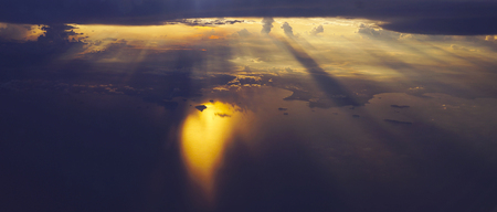 Light rays sunset shining through rich in space clouds,panoramaの写真素材