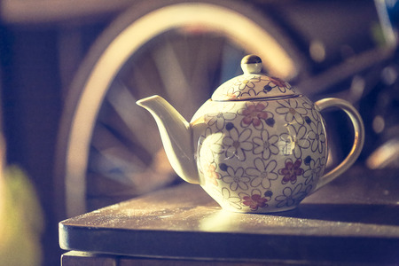 Ceramic teapot, ceramic cup on the wooden table- vintage style effect pictureの写真素材