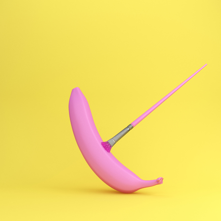 Creative fruit painted made of pink banana on yellow background.minimal fruit idea concept. Creative...