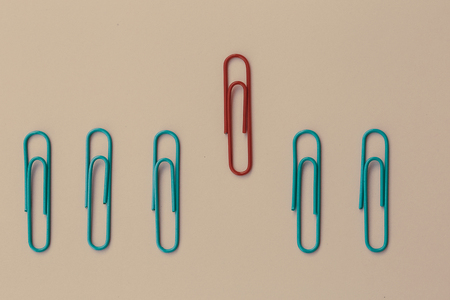 Colored paper red clip outstanding on pink background. minimal concept. Ideas about showing leadership in various ways. education, better businessの写真素材
