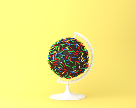 Globe sphere orb chocolate sweets concept on pastel yellow background. minimal idea concept. An idea creative to produce work within an advertising marketing communications or artwork design.の写真素材