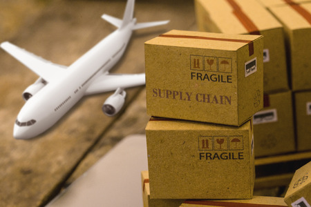 Light brown small boxes with a plane on a laptop keyboard. idea of transportation that can be done...