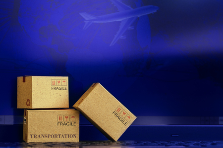 Small paper boxes on notebook with a plane flies behind. An ideas about transportation, international freight, global shipping, overseas trade, regional, or local forwarding.の写真素材