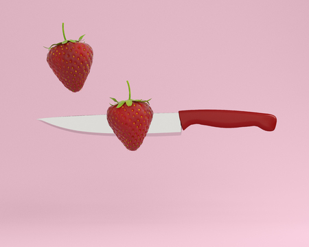 Creative Concept : Strawberry impaled on stainless kitchen knives on pink pastel background. minimal food idea concept. used for graphic design and website.の写真素材