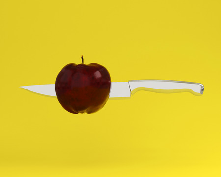 Red apple impaled on stainless kitchen knives on yellow background. minimal  idea concept. creativity food is intelligence having fun for produce work within an advertising marketing communications.の写真素材